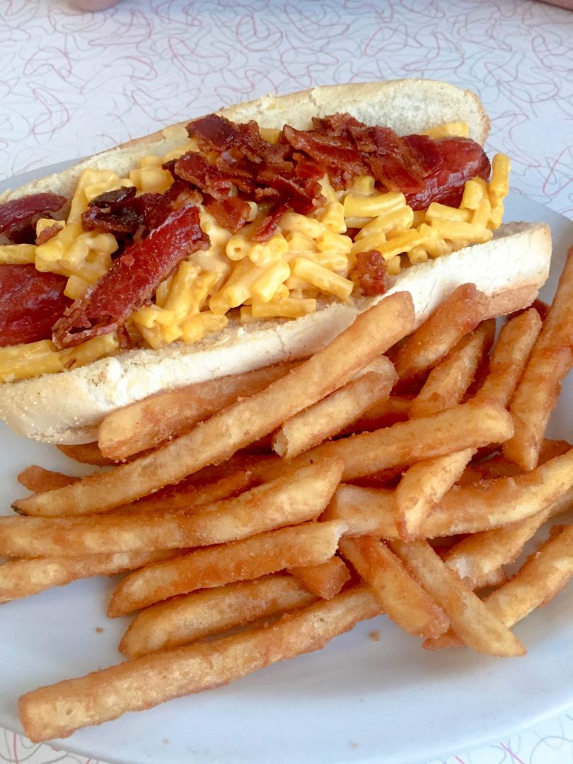 A Bacon Mac & Cheese Hot Dog with fries - classic road trip food