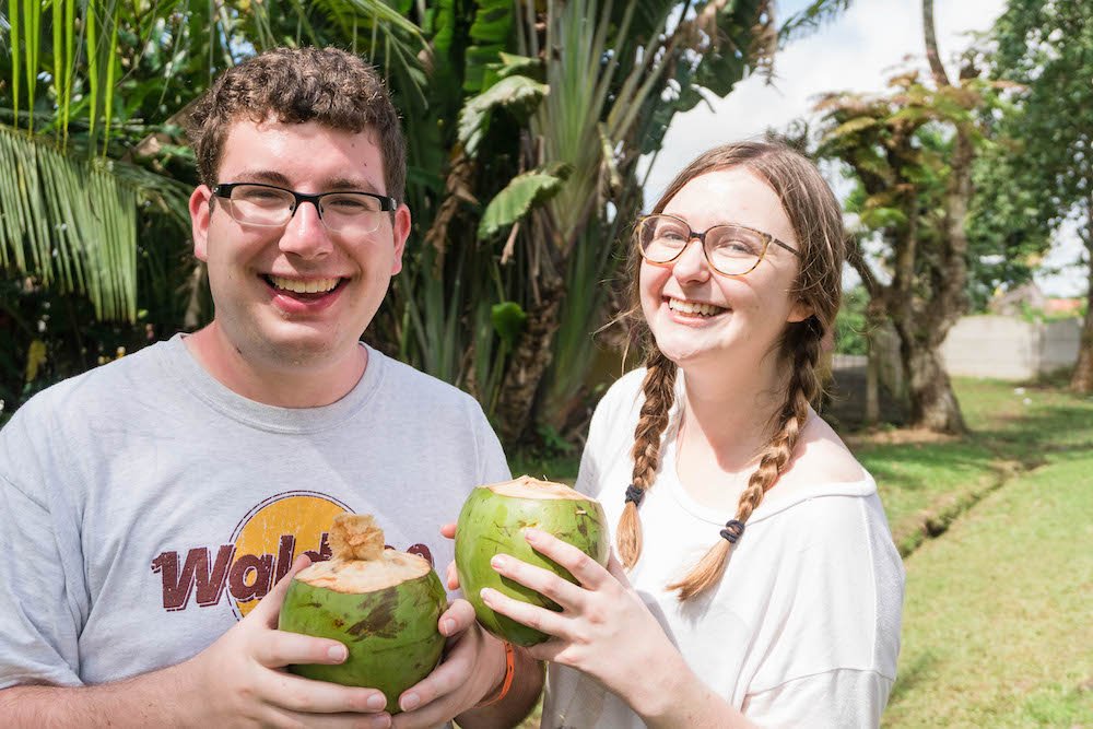 Addie and Daniel holding coconuts and smiling