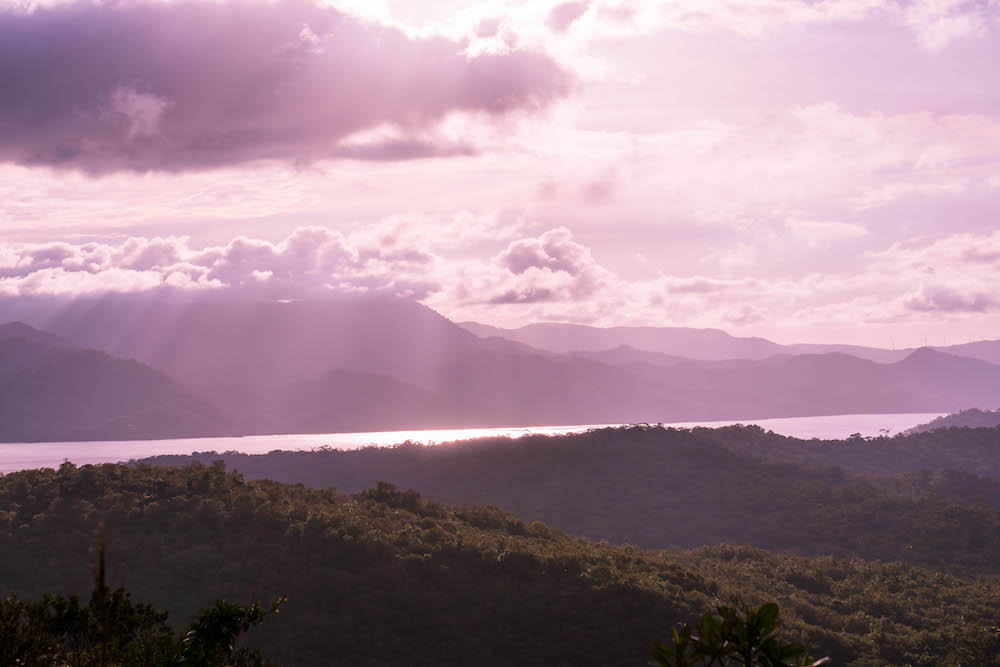 A beautiful purple sunset over Lake Arenal in La Fortuna, Costa Rica with mountains in the background