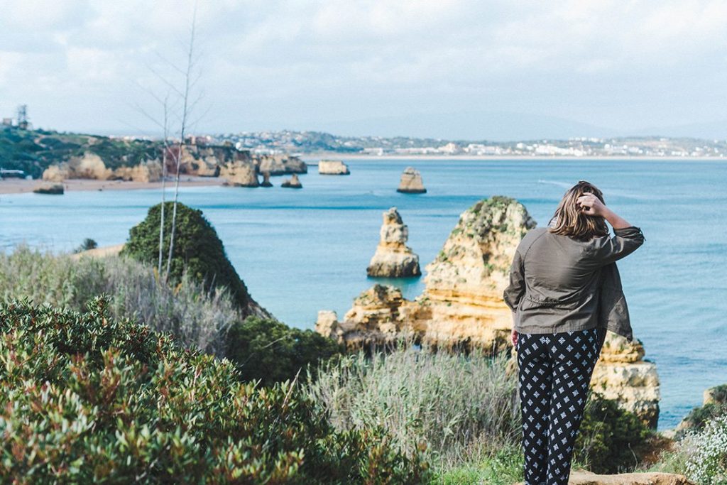 Madison staring out at the cliffs of Lagos, Portugal, a great solo female travel destination