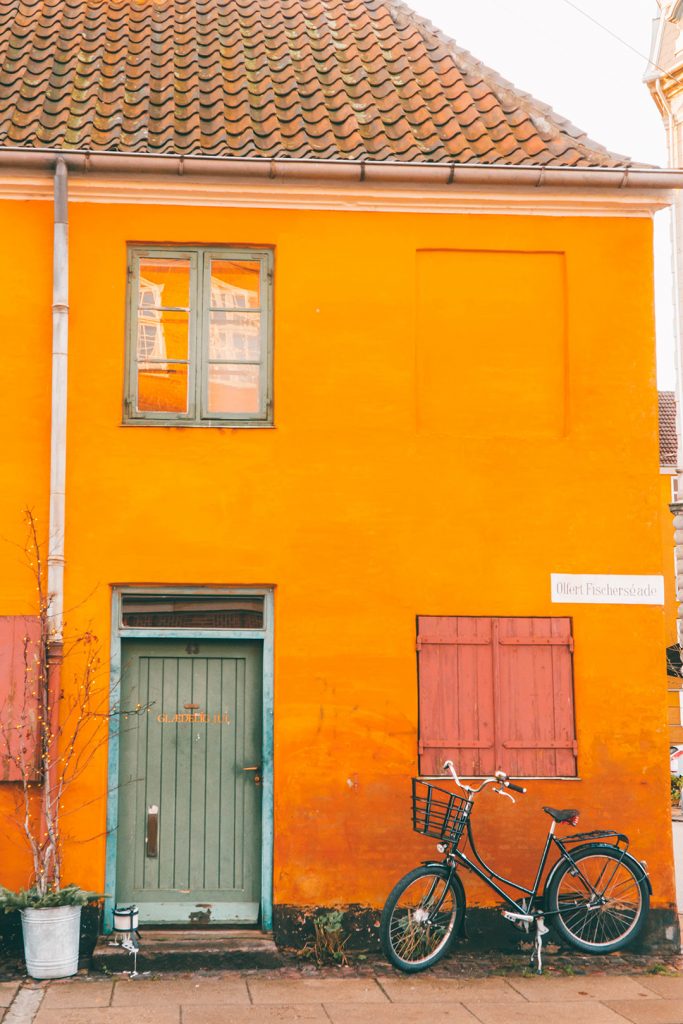 A bicycle outside of an orange house in Nyboder Copenhagen