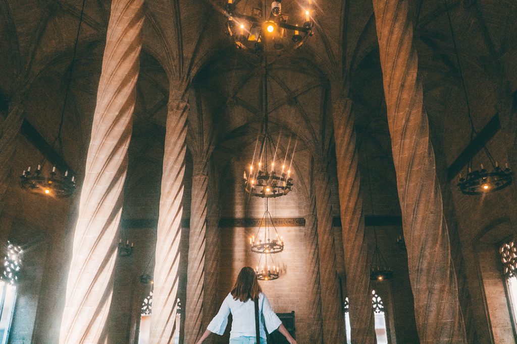 Addie gazing up at the spiraling columns and cathedral-like ceilings of La Lonja in Valencia, Spain