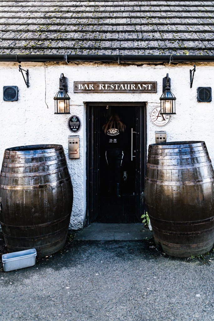 2 large barrels flanking the door of an inn