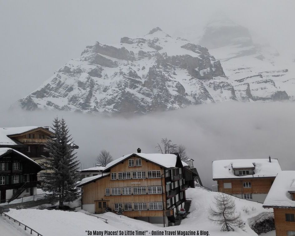 wooden houses covered with snow in front of a mountain in Murren, Switzerland