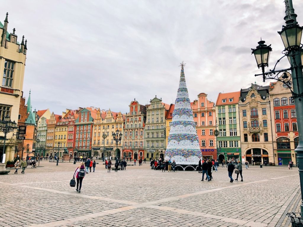 a christmas tree in a square of colorful houses on Wroclaw, Poland - one of the best places to visit in Europe in winter