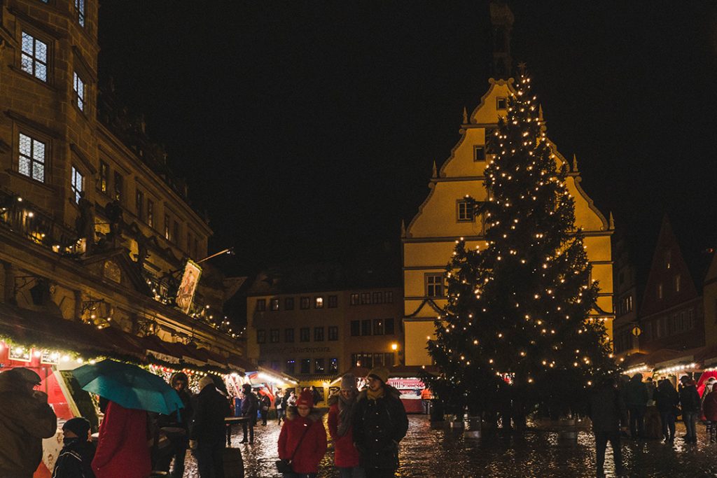 A large evergreen tree in the Rothenburg ob der Tauber Christmas market square at night