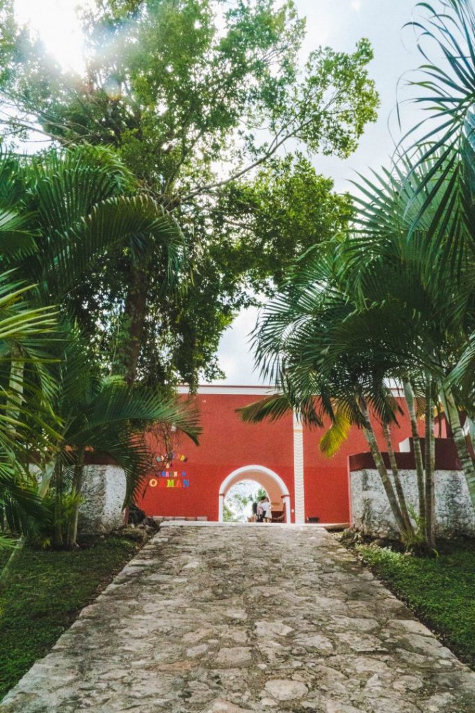 a red building - the entrance to cenote san lorenzo oxman, one of the valladolid cenotes