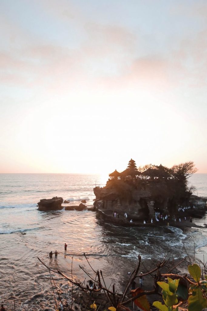 tanah lot temple, perched on a rock in the sea, at sunset