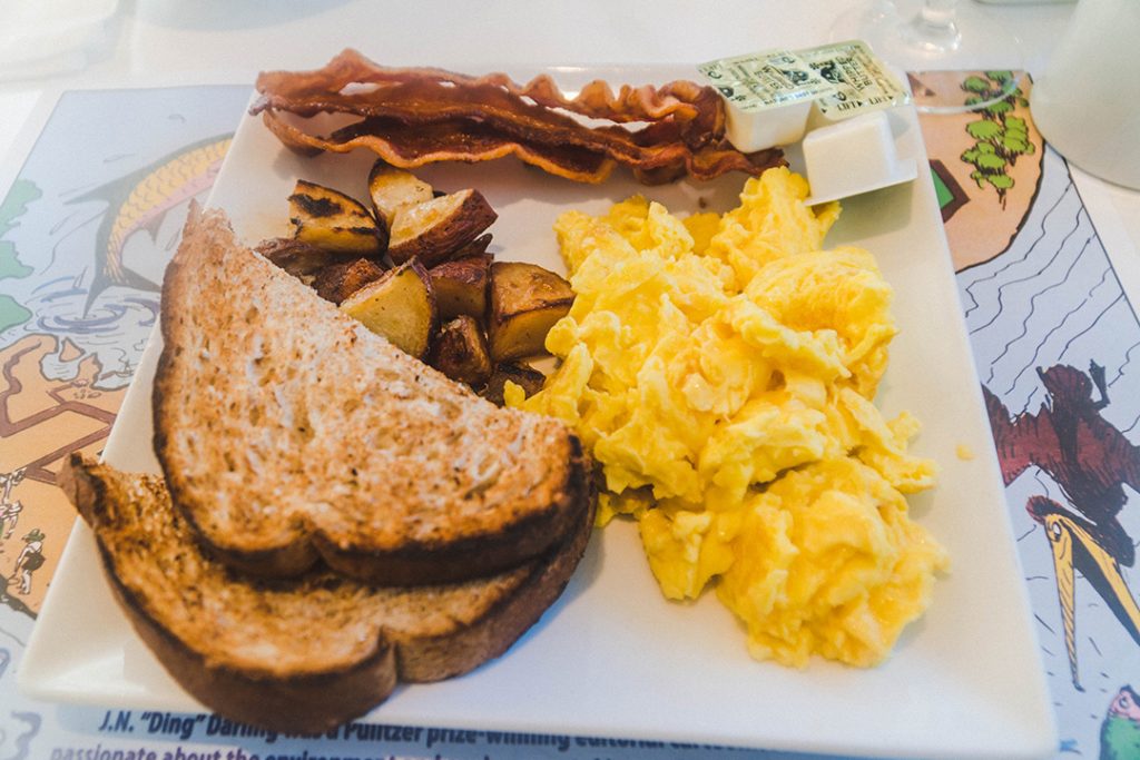 bacon, eggs, toast, and breakfast potatoes on a white plate