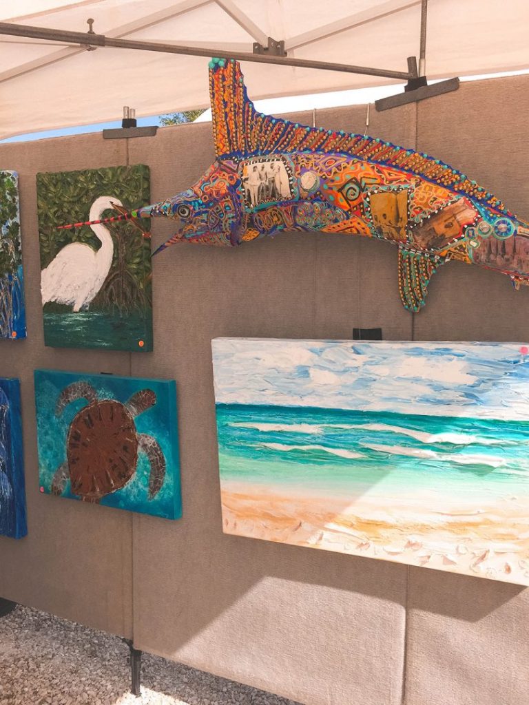 a wall full of paintings of beach and sea animals