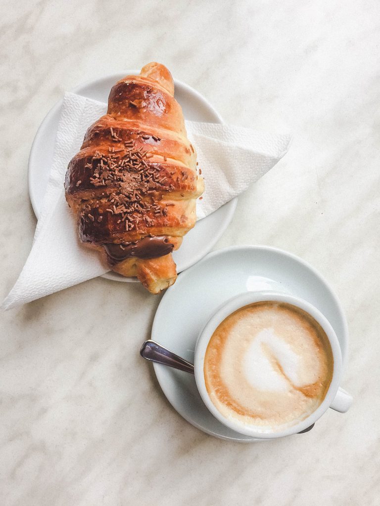 a chocolate croissant and cappuccino 