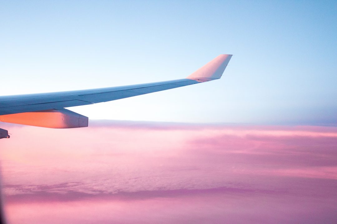 plane wing over pink clouds