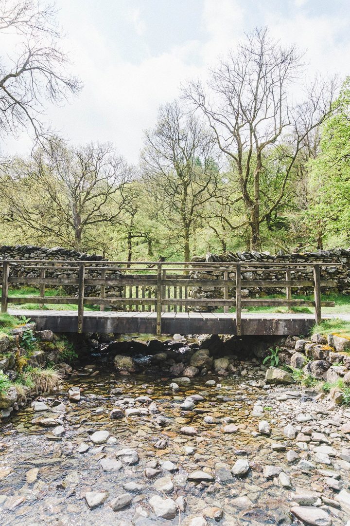 A cute wooden bridge over a small river in the Lake District, UK