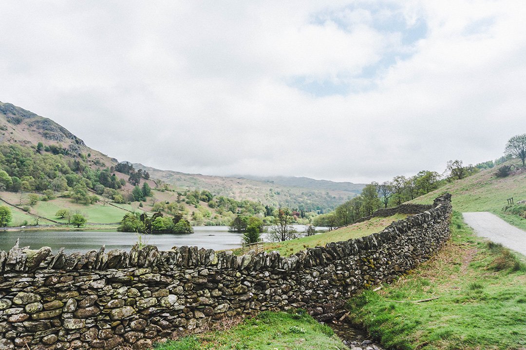 An old stone wall stretching across a field in the Lake District, UK