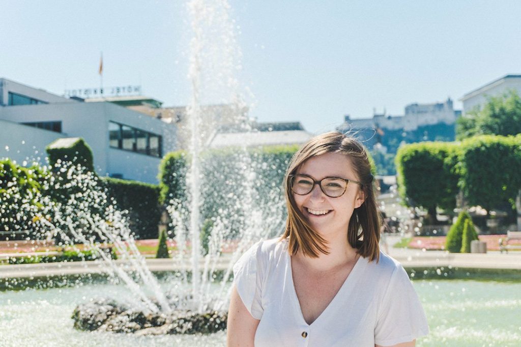 Addie smiling by the fountain in Mirabell Gardens Salzburg, Austria