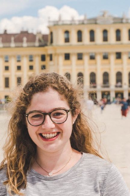 Angela smiling in front of Schonbrunn Palace in Vienna, Austria during her study abroad semester