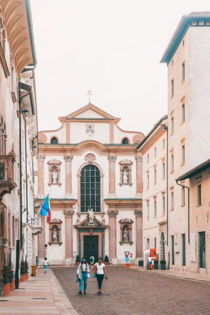 A church and street at golden hour in Trento, Italy