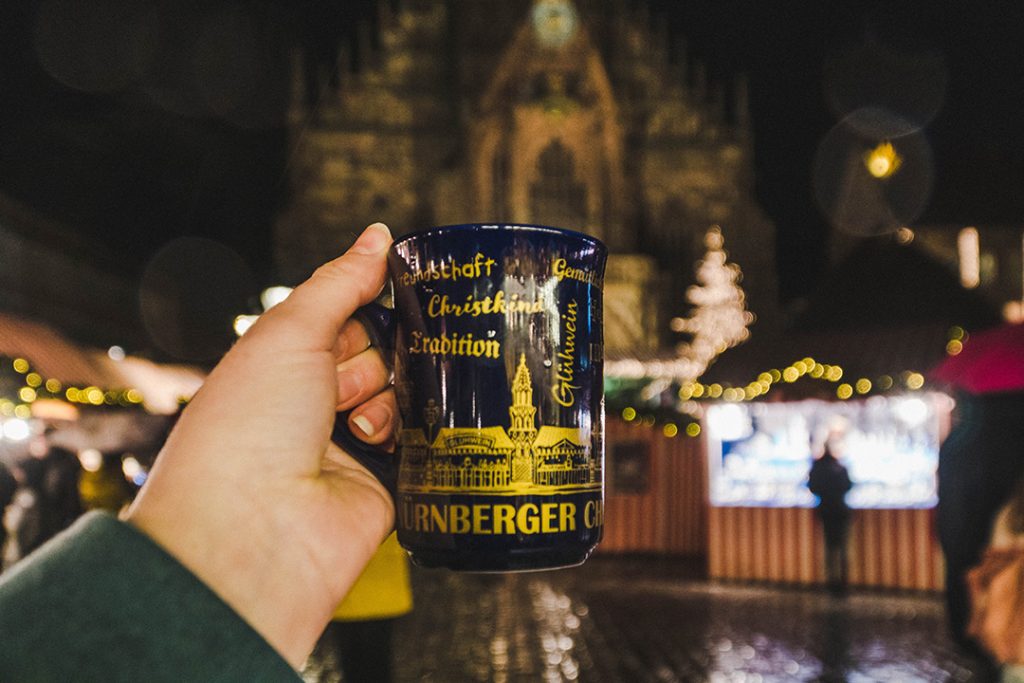 a hand holdin gup a gluhwein mug at the nuremberg christmas market, a great solo female travel destination