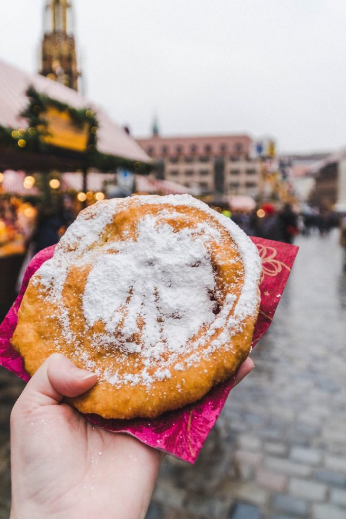a Kuchle donut with the nuremberg christmas market seal in powdered sugar