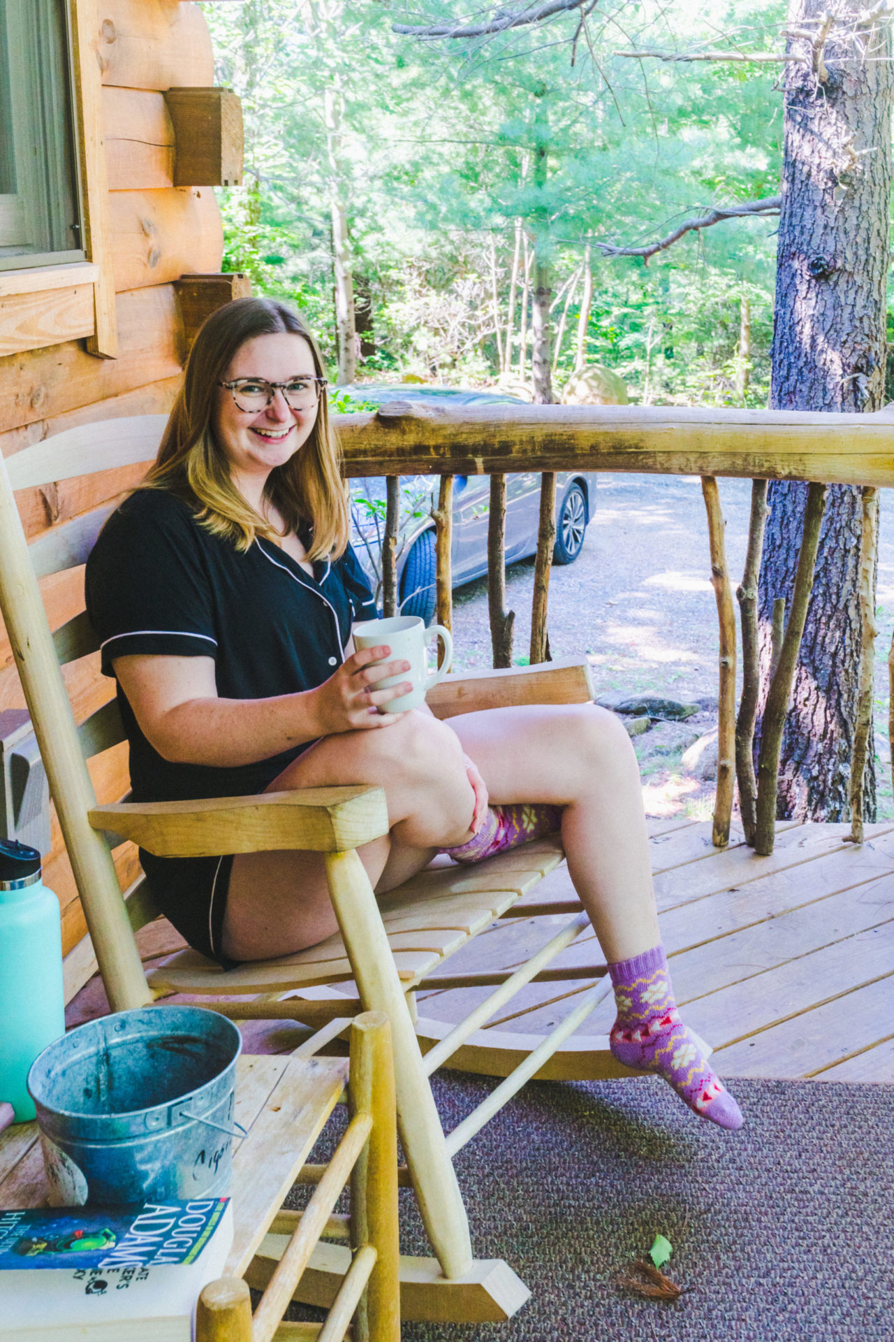 addie sitting on a wooden rocking chair with a cup of coffee